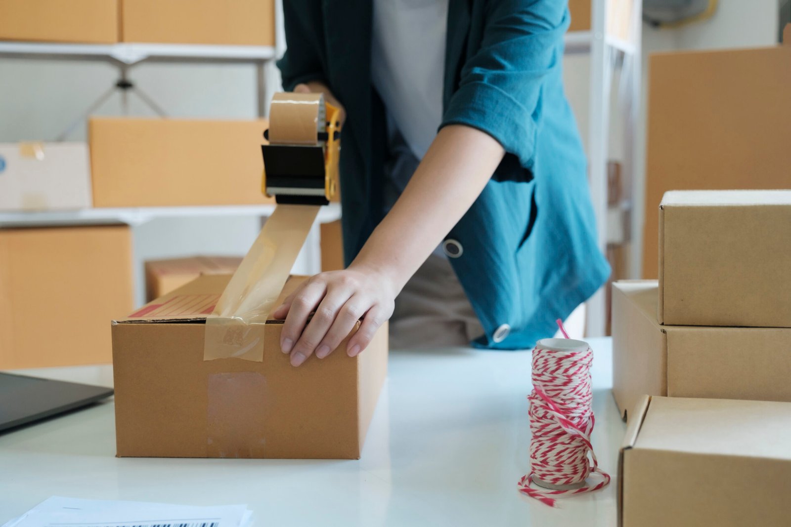 young woman packing product in box for online order.