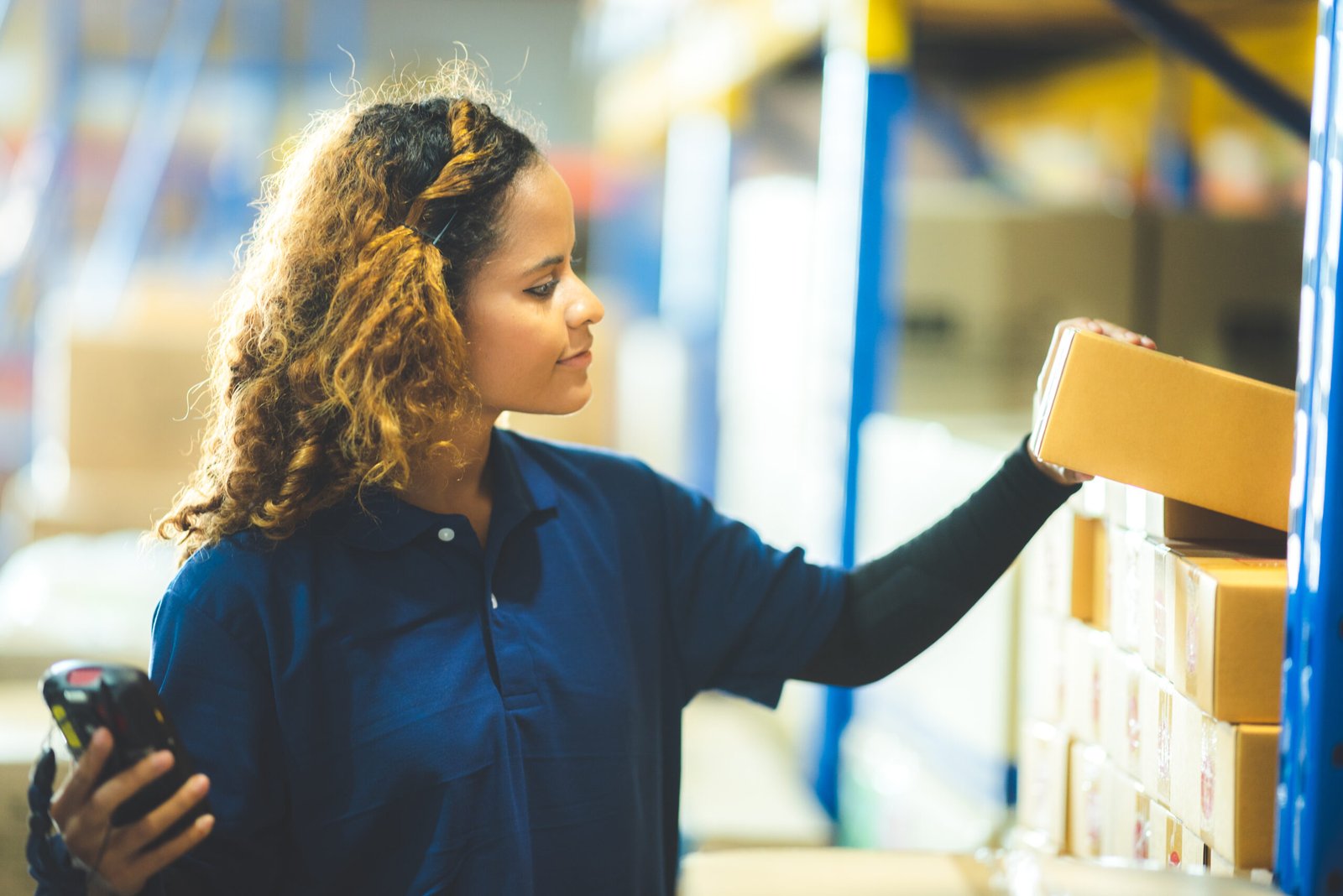 warehouse worker using bar code scanner to scanning box and analyze newly arrived goods for further placement in storage department, working at warehouse.